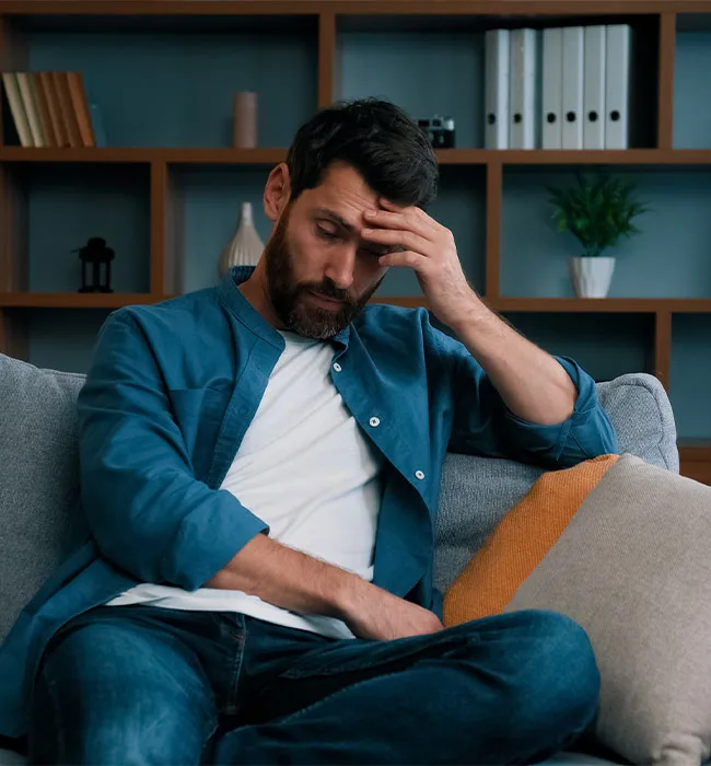 A Man Looking Distressed With His Head In His Hands, Thinking For An Adderall Detox Center