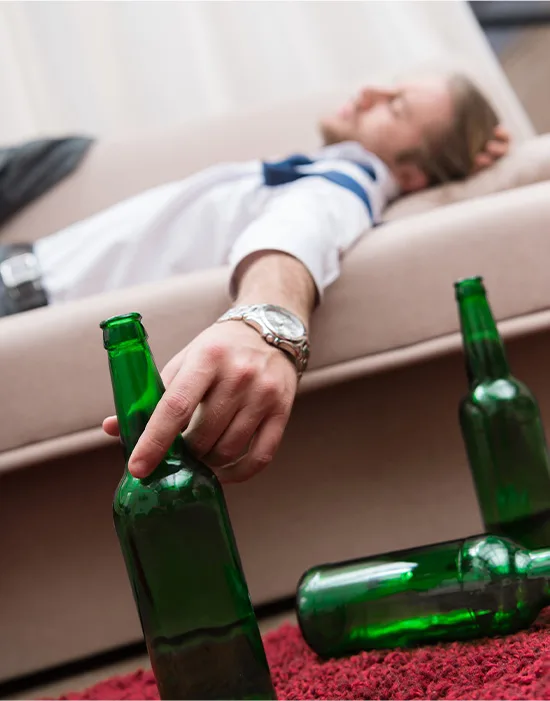 Intoxicated Man Beside Alcohol Bottles, Hinting At Need For Detox From Alcohol